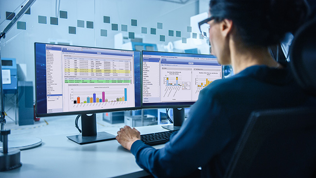 Modern Electronics Factory: Female Electrical Engineer Works on Computer with CAD Software. Developing PCB, Microchips, Semiconductors and Telecommunications Equipment