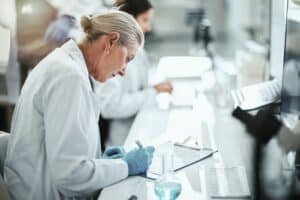 Clipboard,,Woman,And,Scientist,Writing,In,Laboratory,For,Medical,Research