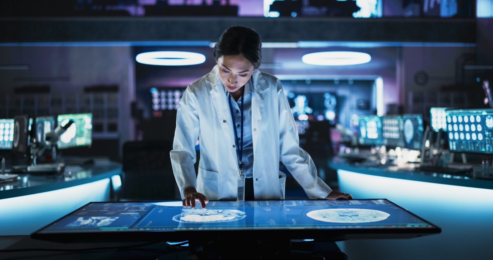 Female,Asian,Neuroscinetist,Using,Interactive,Touch,Screen,Table,With,Mri